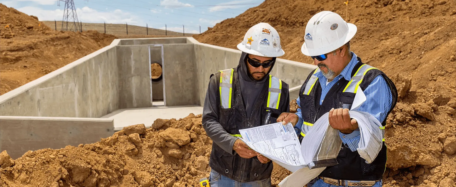 Two Alpine crew members reviewing a blueprint