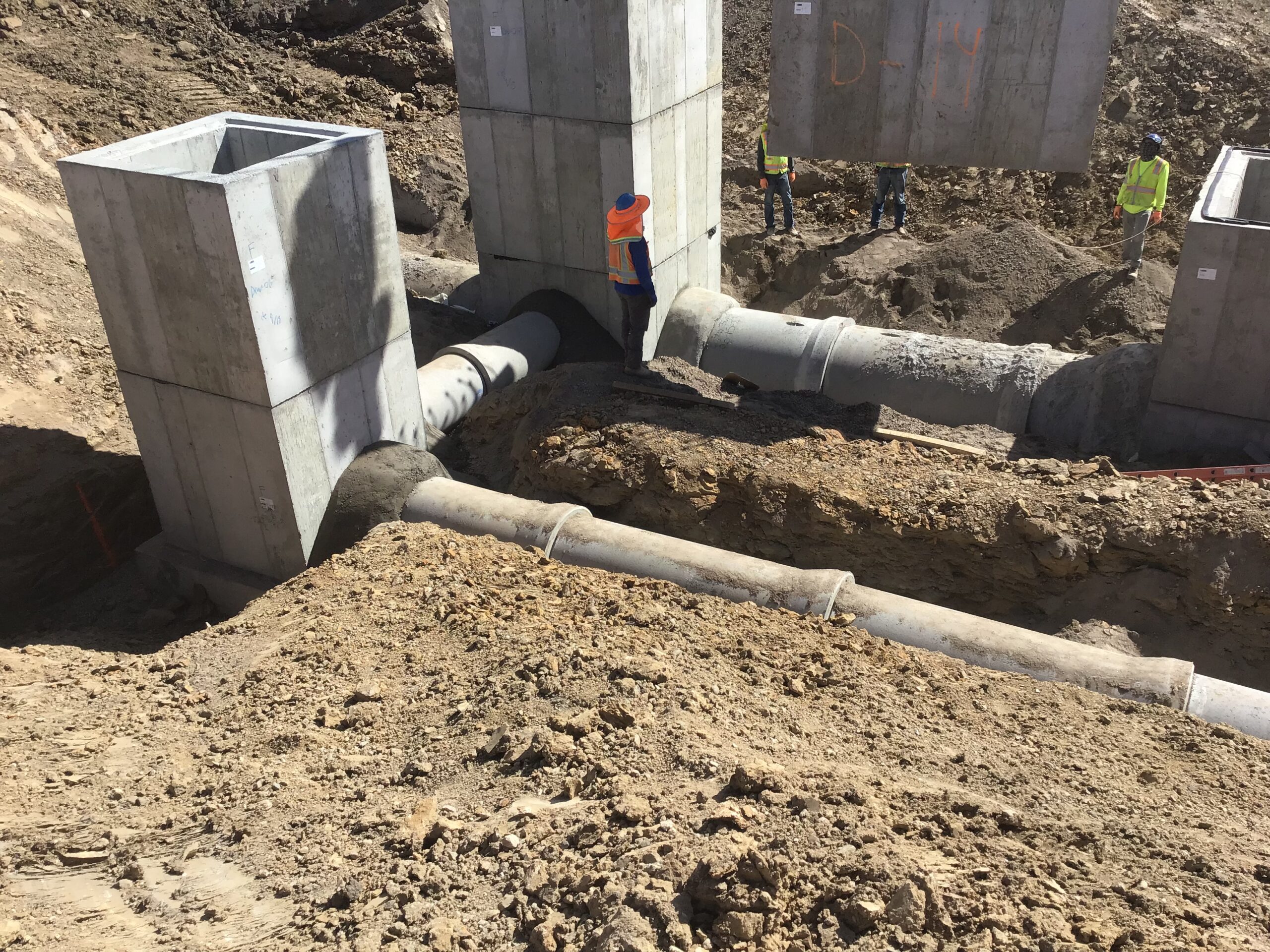 Crew installing precast concrete manholes and storm pipes