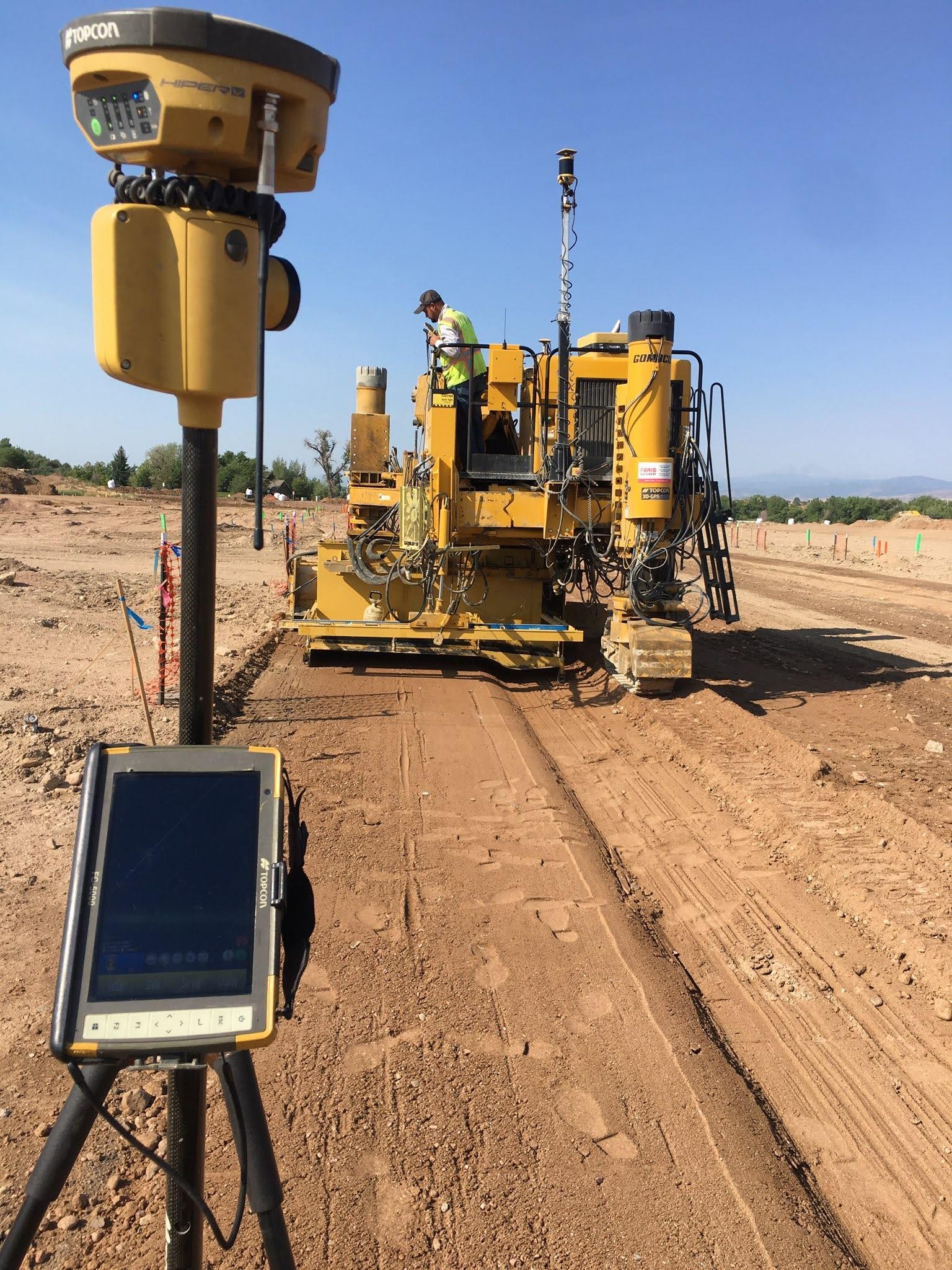 GPS-guided grading machine preparing dirt roadway
