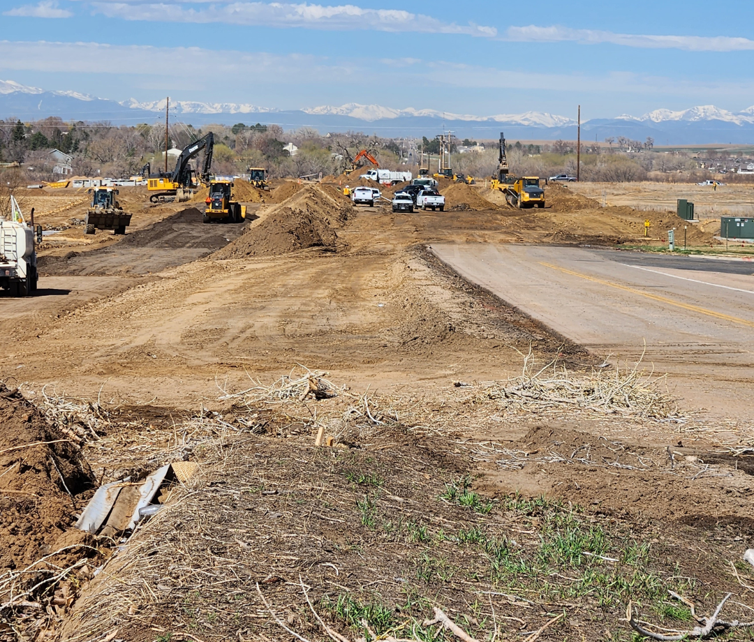 Wide view of active roadway construction with heavy equipment